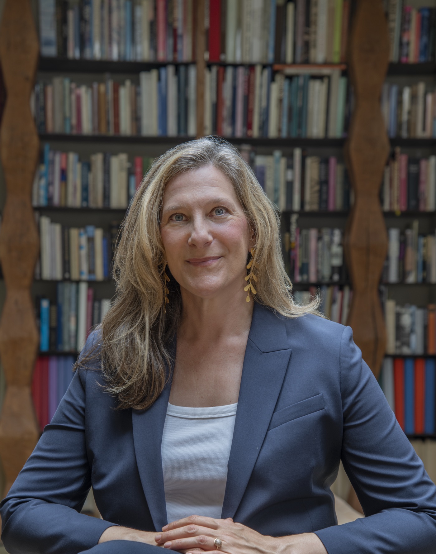 Jivanna Okolica, LCSW-R, seated in front of a bookshelf